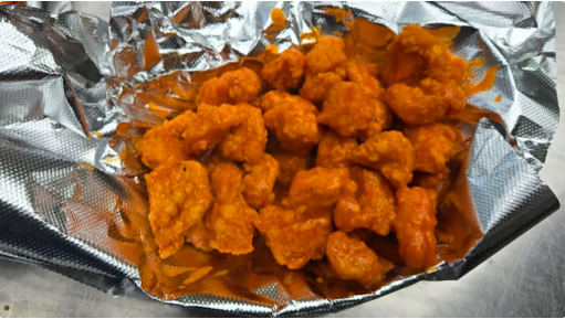 Crispy buffalo chicken bites on foil