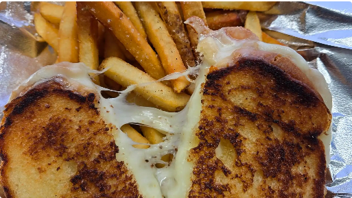 Grilled cheese sandwich with melted cheese pull and seasoned fries