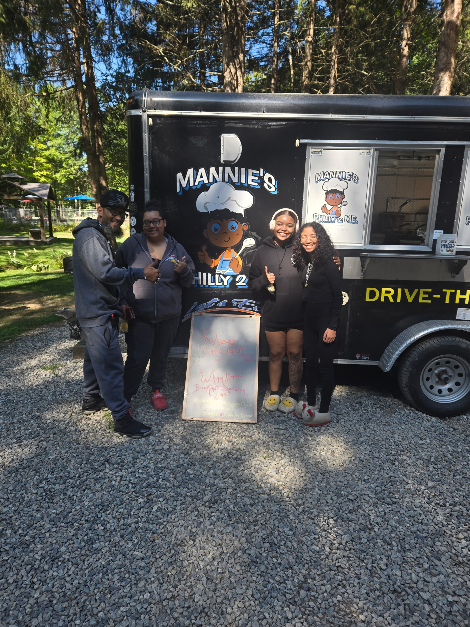 Customers and crew smiling in front of the Mannies Philly 2 Me truck